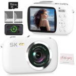Camcordy 5K Vlogging Camera in white on a tidy desk next to a mini tripod, 32GB card, and travel notebook